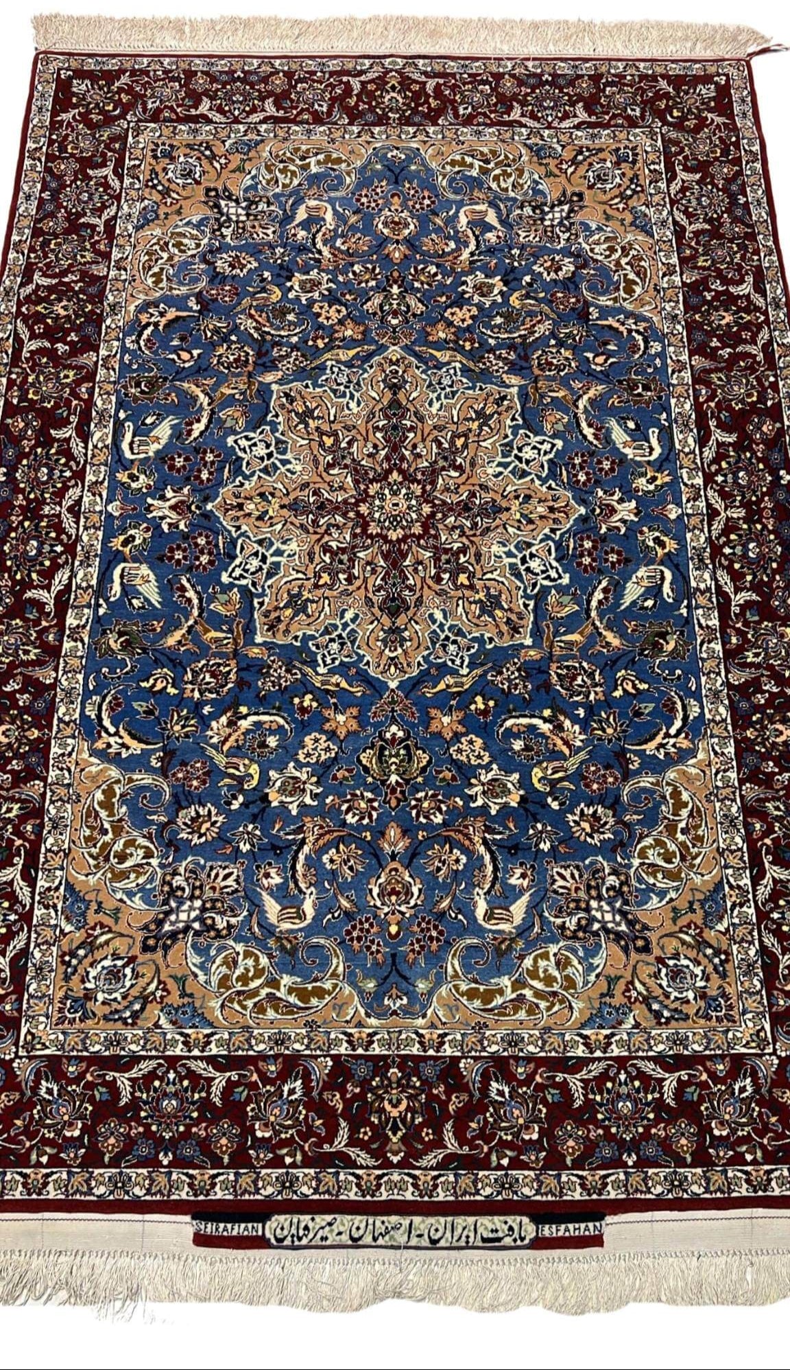 "Hand-knotted Seirafian Persian rug with intricate blue and beige floral patterns, made from wool and silk, showcasing Isfahan craftsmanship."